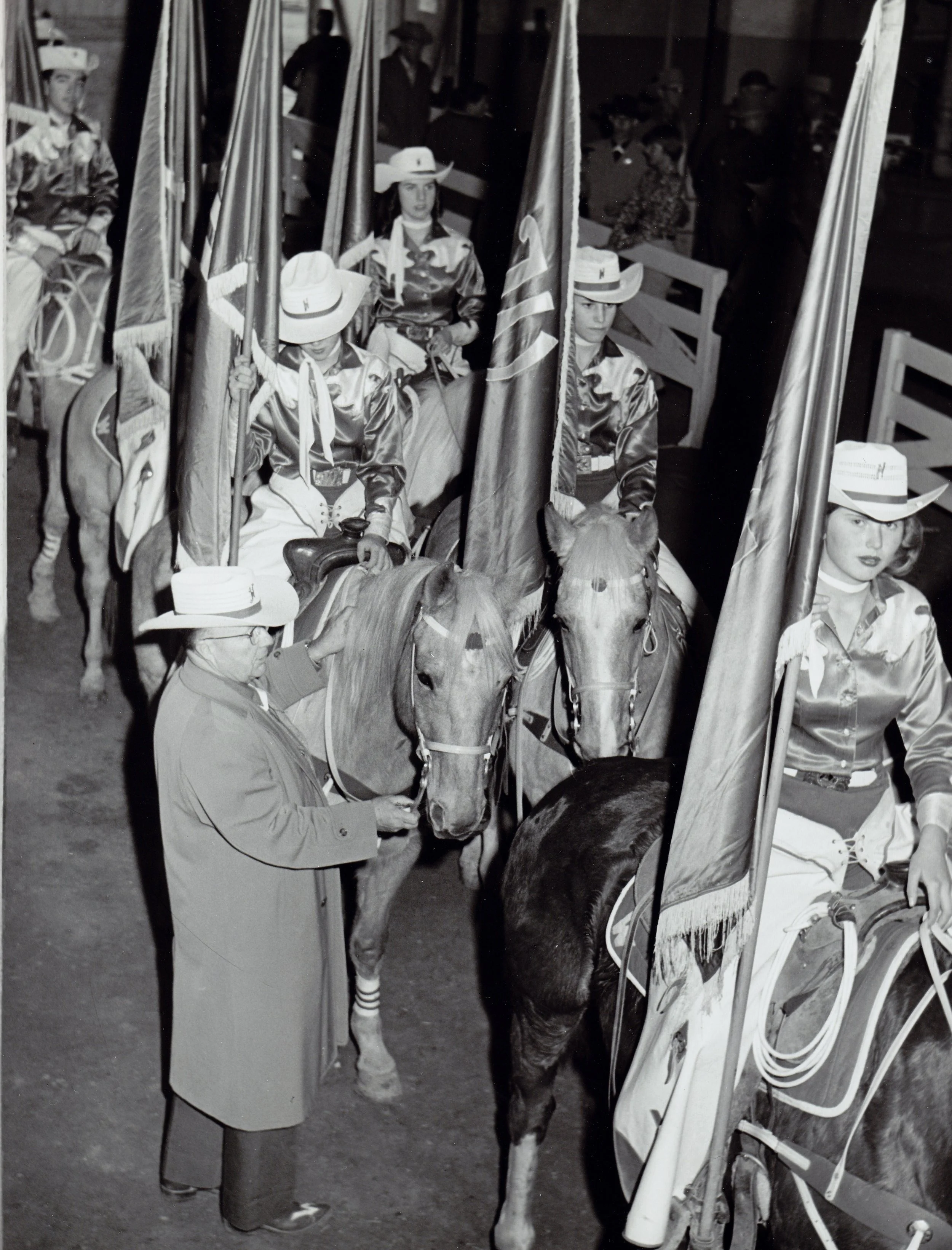 Westernaires founder and Director, Elmer E. Wyland, stands with the lined-up Grand Entry riders in the paddock of the 1961 National Western Stock Show. Jody Williford is on the far right.