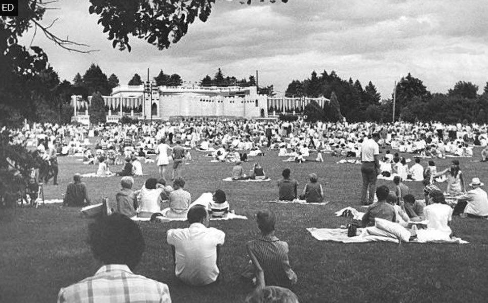Denver Opera Foundation’s 1969 production of Camelot , in Denver’s Cheesman Park. The elaborate set built around the park’s pavilion was designed to look like Camelot castle, replete with towers, a gatehouse, and drawbridges over the orchestra pit “moat”. An estimated 8,000 people attended the production of Camelot on Tuesday night alone. Many brought picnic fare and enjoyed the opera from the ground.