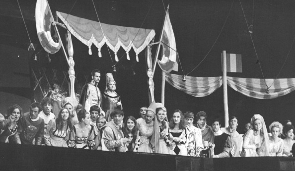 Wynne Miller as Queen Guinevere and Robert Peterson as King Arthur are joined by court attendants in watching a joust in the production Camelot . Camelot was the 36th annual production free to the public by the Denver Opera Foundation.