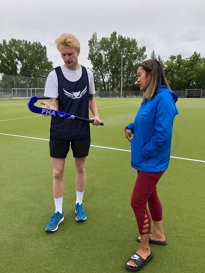 Thu showing teaching Matt about the different ways the field hockey stick can be used.