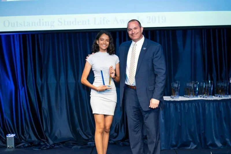 Afsaana Kiara Mohammed receives an award on behalf of her organization, the Born Different Advocate Alliance, which honored its efforts in creating a more inclusive environment on campus and help connect disabled students with equal educational and career-related opportunities.