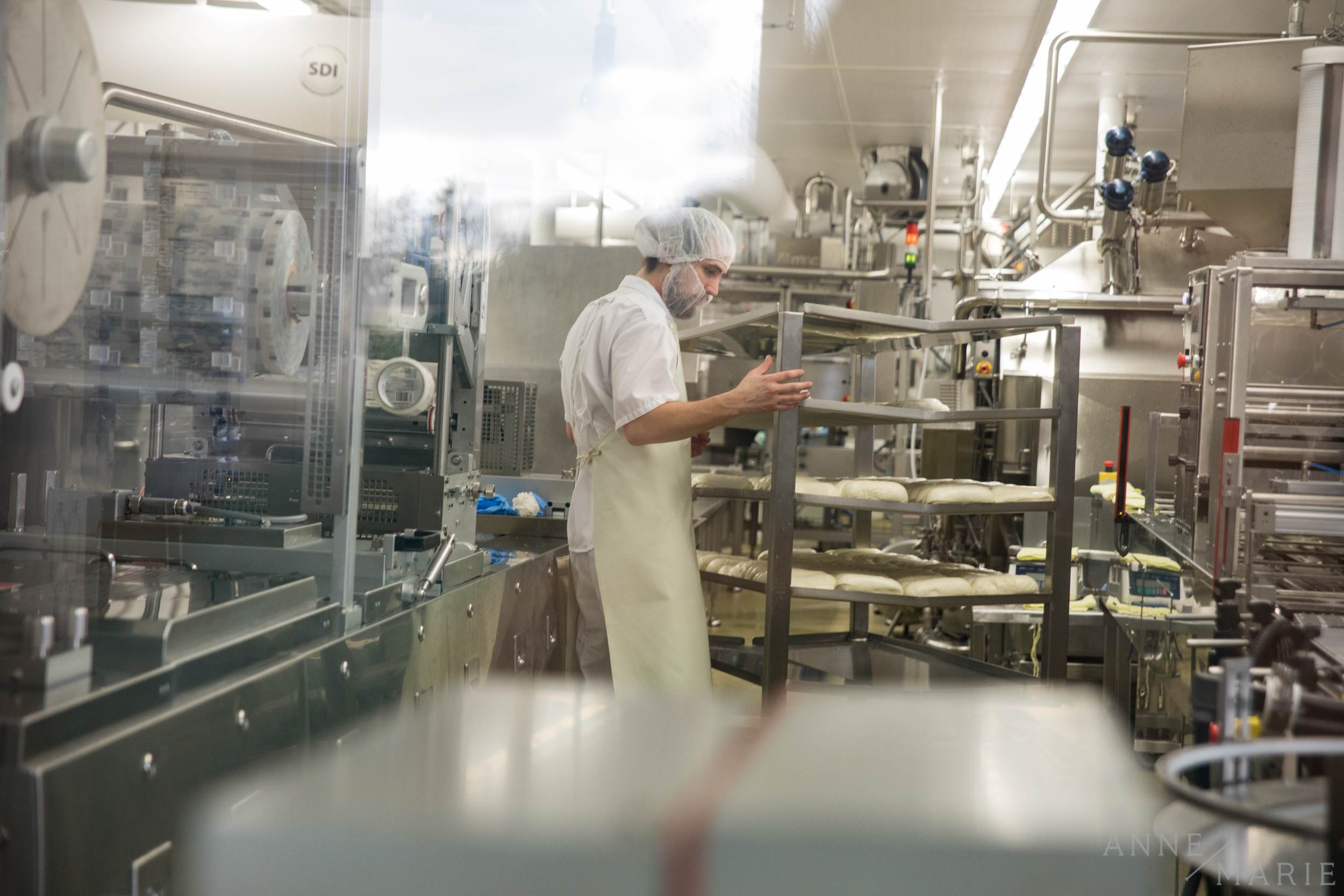  One of the employees moves some of the fresh cheese. 