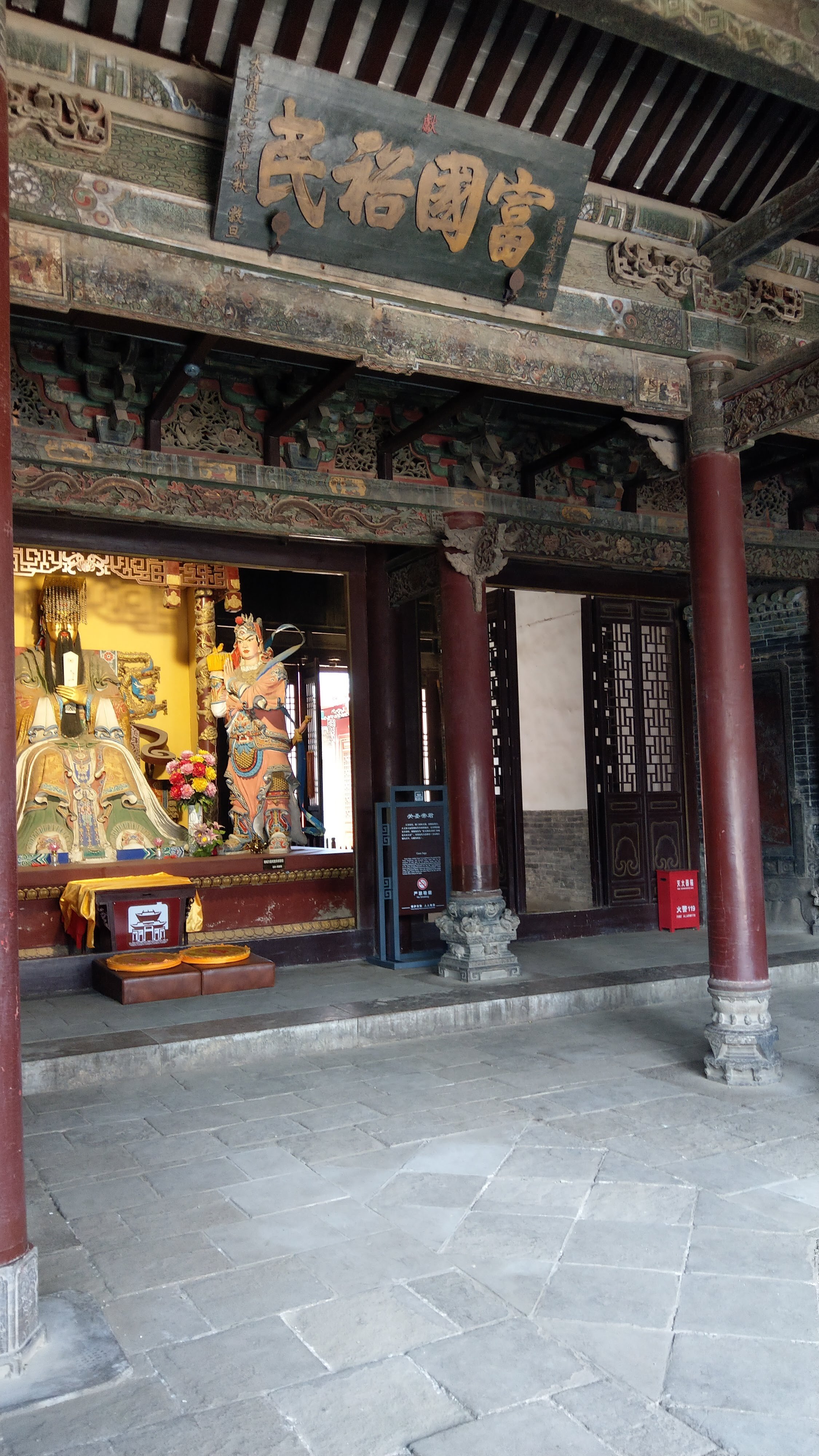 Grandpa slept on the floor at this very spot on that night someone called his name. A statue of guangong presides over the room.