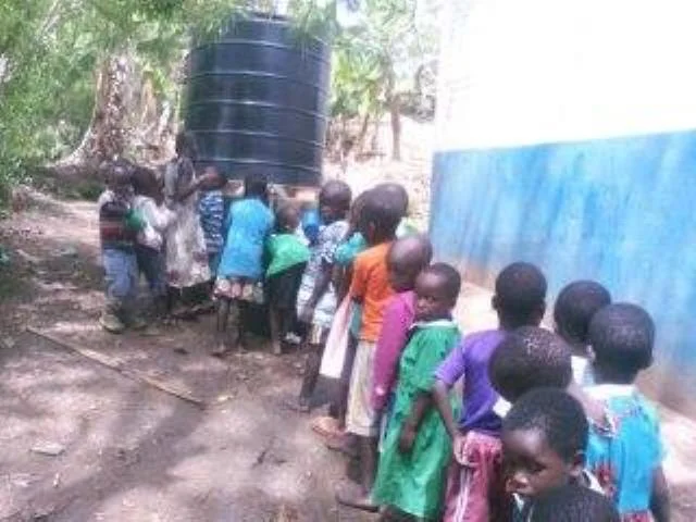 Kids line up for water at Robyn's Nest