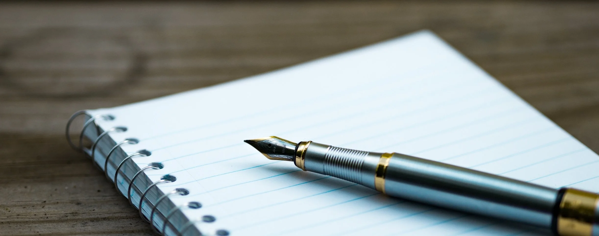 unsplash aaron-burden-123584 blank notebook and pen.jpg