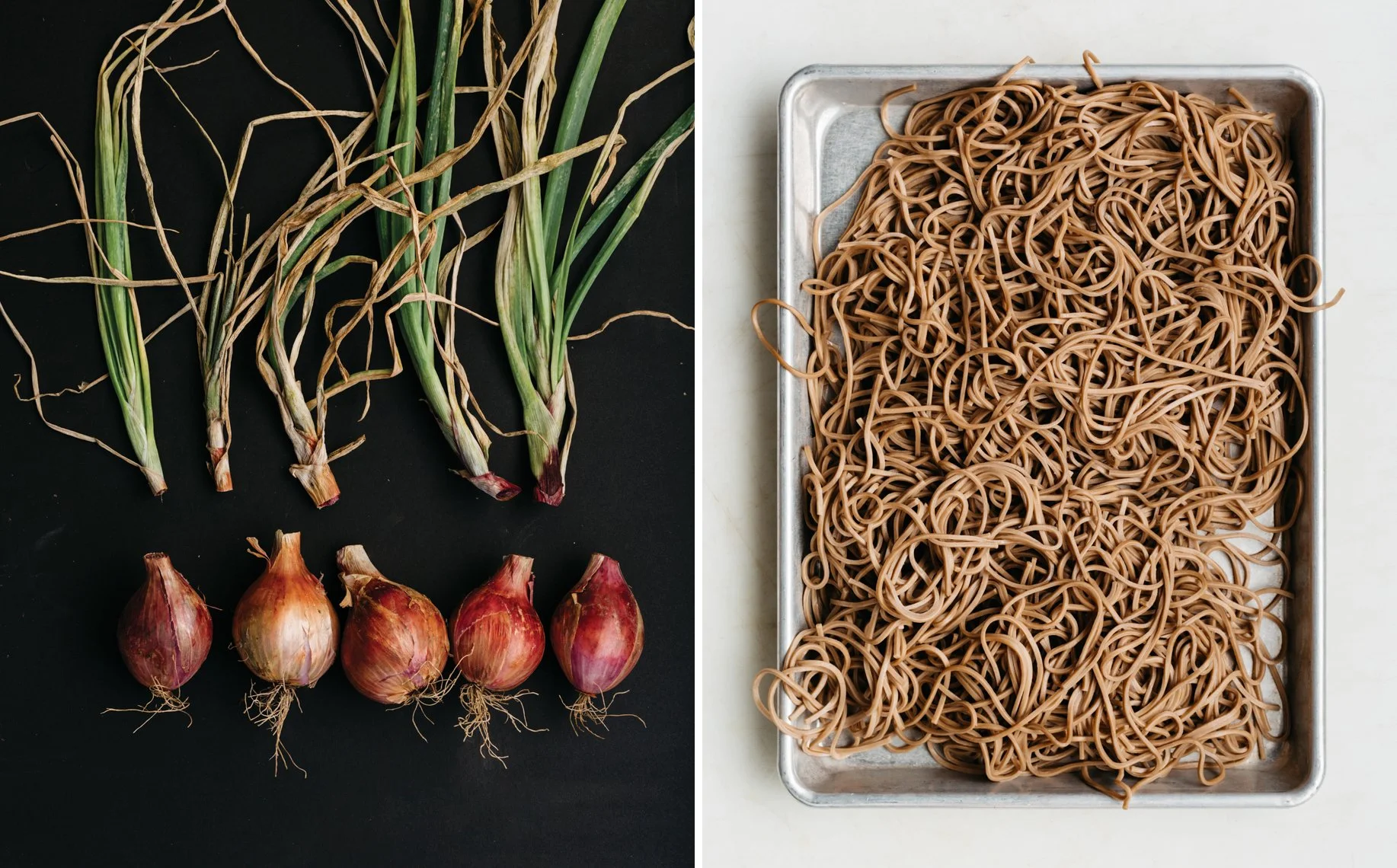 Green onions and shallots on a black background, next to a tray of cooked brown noodles on a white surface.