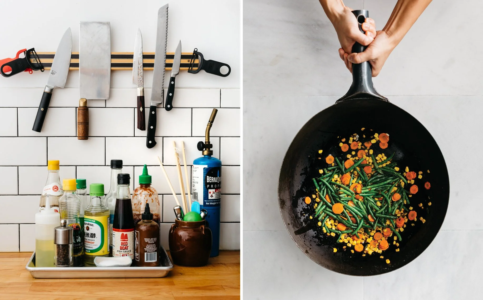 A kitchen countertop with various knives and utensils hanging on a rack, including a large chef's knife, cleaver, and bread knife, along with bottles of condiments, sauces, and seasonings, and a coffee pot. Next to it, a hand holds a frying pan conta
