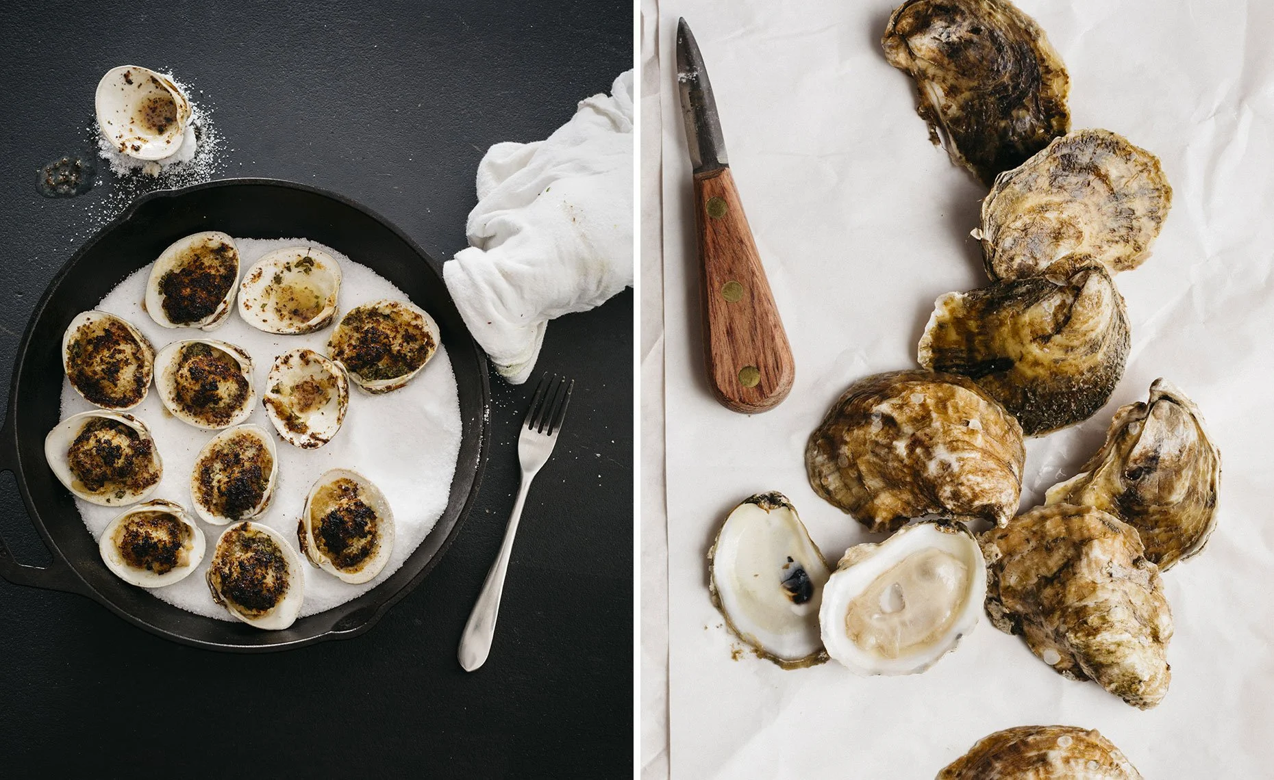 On the left side, a cast iron skillet filled with cooked oysters topped with herbs, salt, and seasoning, with a fork, a cloth, and a salt container nearby. On the right side, a group of raw oysters with opened shells, a knife with a wooden handle, an
