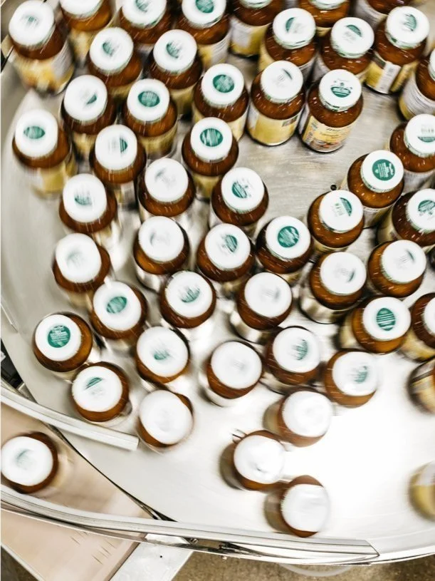 Multiple bottles of medication or dietary supplements with white caps displayed on a circular rotating rack in a store.