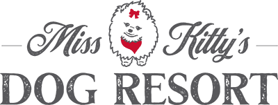 Miss kitty's Dog Resort logo featuring a dog's face with a red heart-shaped nose and a red bowtie, with the text 'Miss Kitty's Dog Resort'.