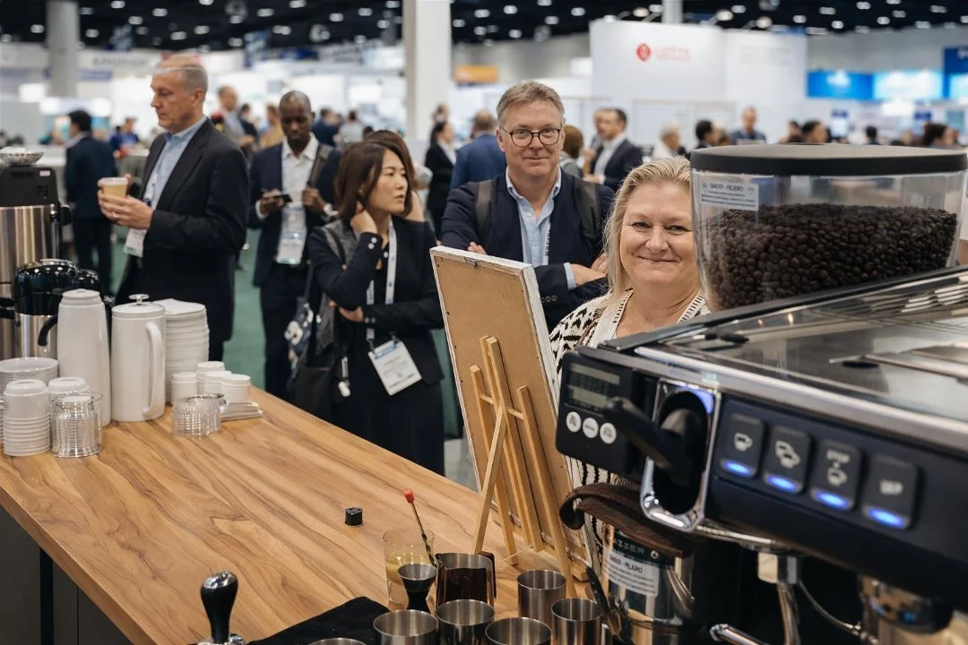 Guests networking around a Rugged Coffee espresso bar during a corporate conference.