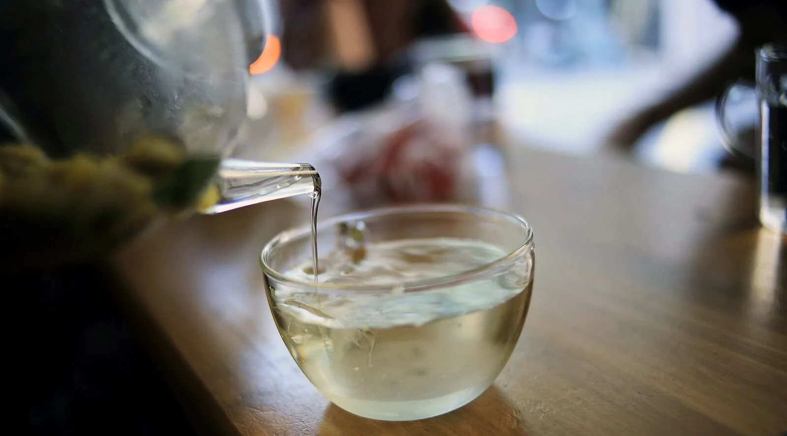 pouring hot white tea in glass cup