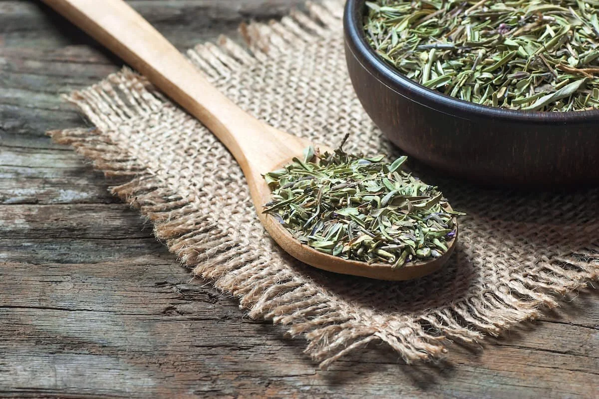 wooden spoon with dried thyme leaves