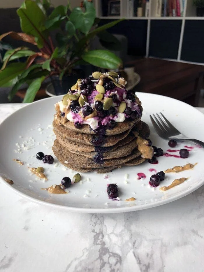healthy fluffy buttermilk buckwheat pancakes topped with toasted almonds and coconut
