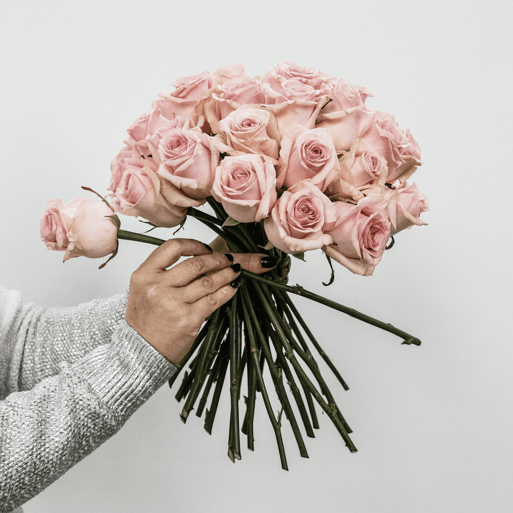 Hands creating a bouquet of pink roses for the Bouquet Workshop at UK School of Floristry