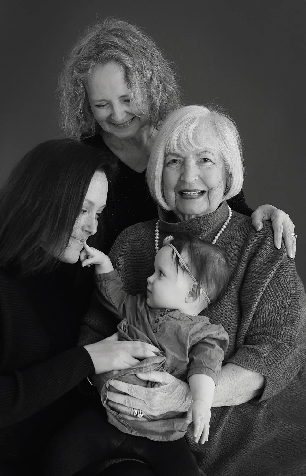 black and white photo of three women and a baby