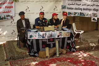 Left to right: Bapir, Mohamed, Lukasz, and Carrie. On the table are photographs of shelling damage and displaced villagers, taken last year. Also on the table are exploded ordinances collected after attacks last year.