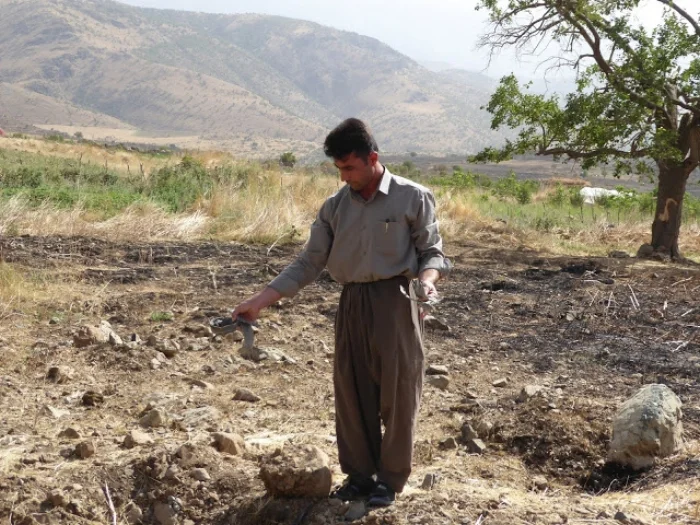 Villager from Barbzin village showing CPT remnants of an Iranian bomb that burnt his field. June, 2016.