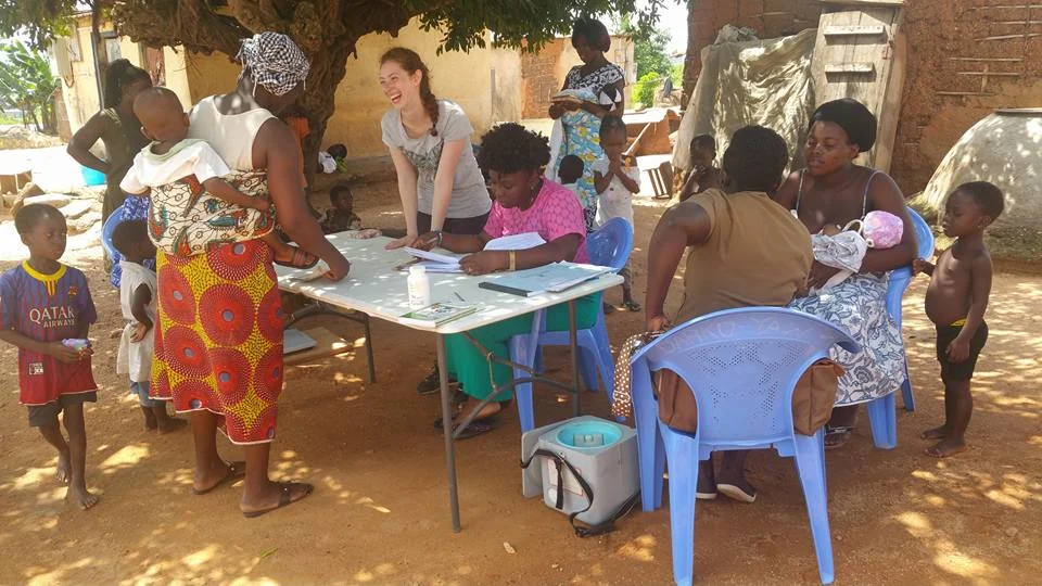 Nutrition Volunteer from the U.K., Bruna, checks the weekly measurements of children in the Point Hope Community Nutrition Outreach program, with the help of Point Hope Staff and Ghana Community Health Nurse.