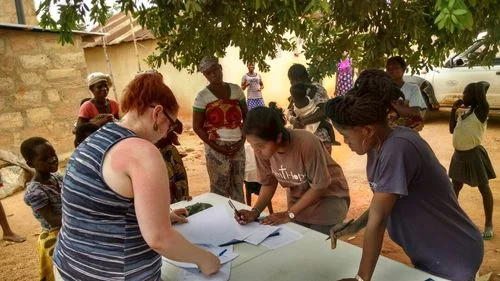 Nicole, from Washington State, Tasneem, from Kentucky, and Stella from Ghana, all working together to process children at the Nutrition Outreach project.
