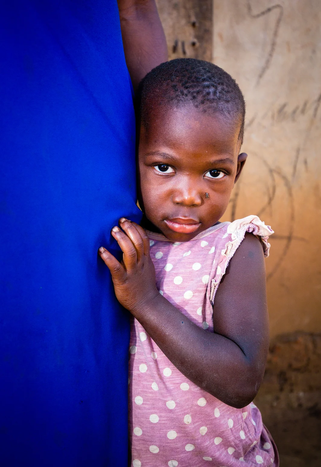 This young girl lives with her family in a small village near Namungalwe, Iganga District, Uganda. Her family has benefitted from the Uganda Village Project’s programs to improve the health of Ugandan villagers by providing medical services, including testing for HIV and malaria, improved water access, and education about better hygiene practices. Taken in Iganga District, Uganda. July 2018. Photo by Ben Blankenship.