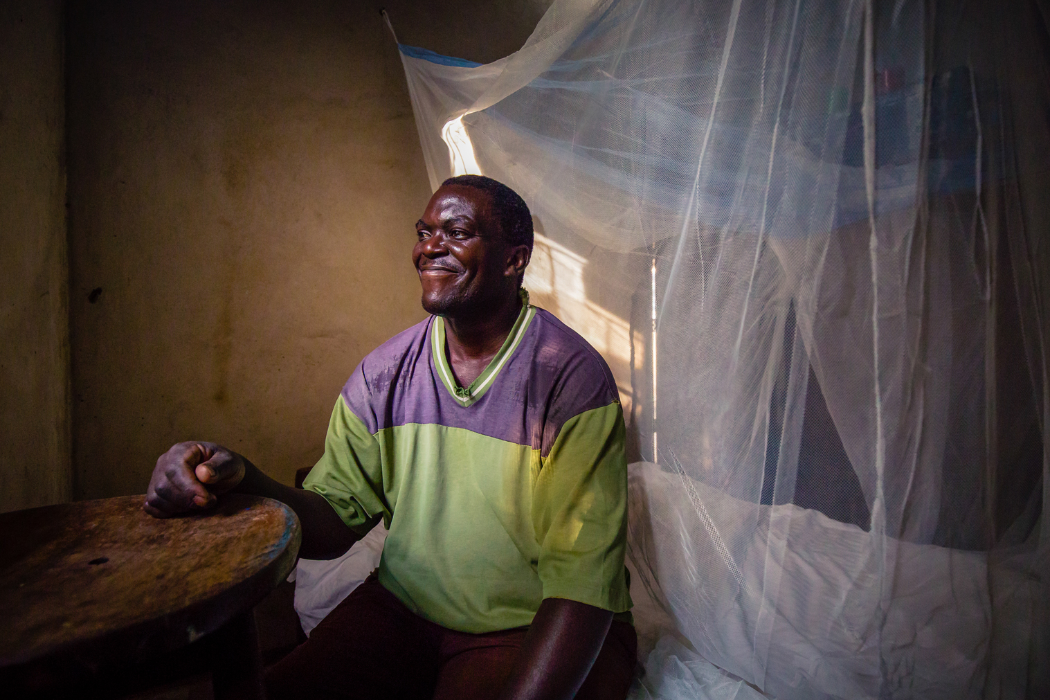  This is Timothy, a Ugandan living in a rural village near Namungalwe, Iganga District, Uganda. In all of Uganda, malaria is a constant risk, but especially so in the villages.  Here, Timothy displays his mosquito net, the first line of defense again