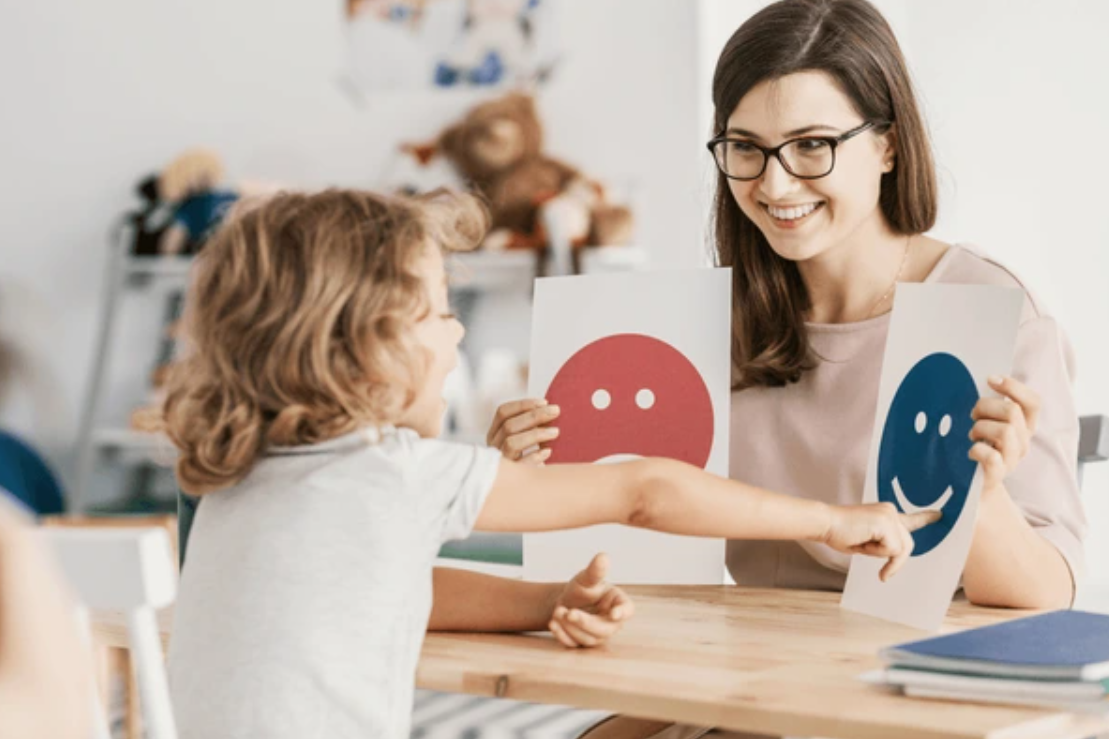 Child and adult exploring emotion cards together