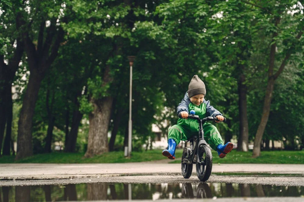 Child riding a bicycle in a leafy park