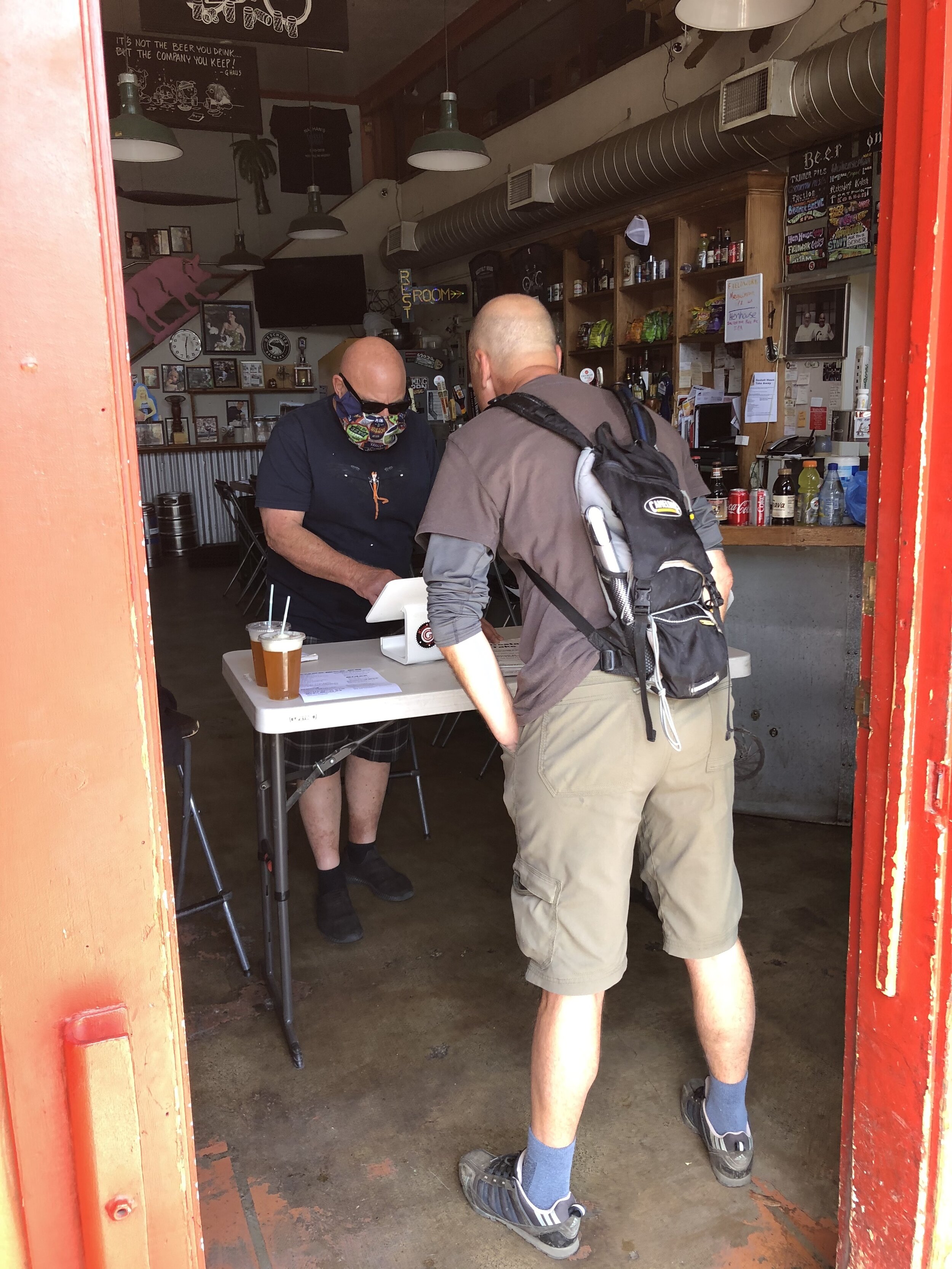 Fairfax' Gestalt Haus reopened for take out beer &amp; brats.  Drinking beer through a straw?  Vise, the owner in mask, can't get employees to return as they're making too much $ with unemployment.