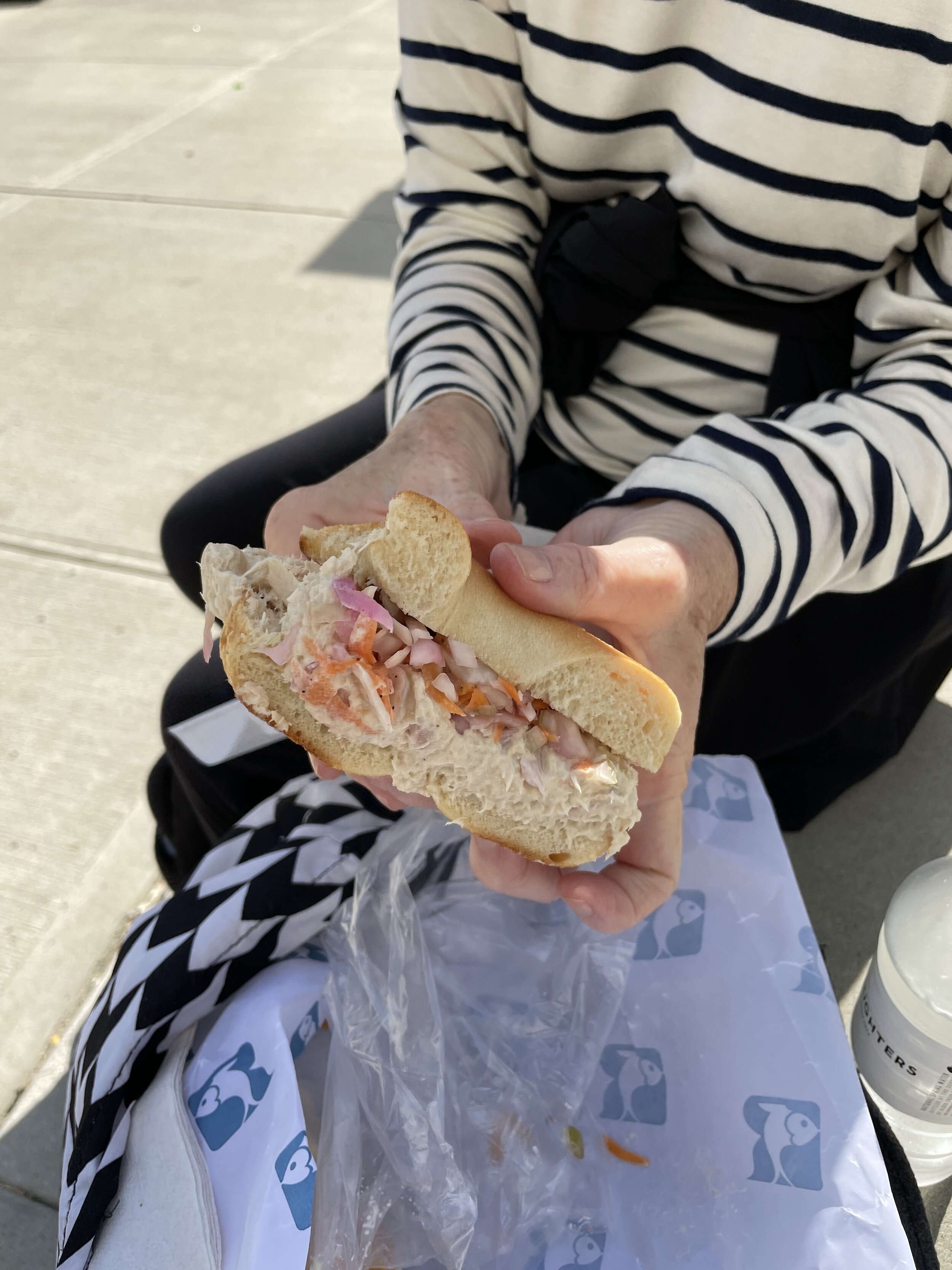 Tuna fish salad with butter &amp; pickled, crunchy slaw on a lightly toasted bagel.