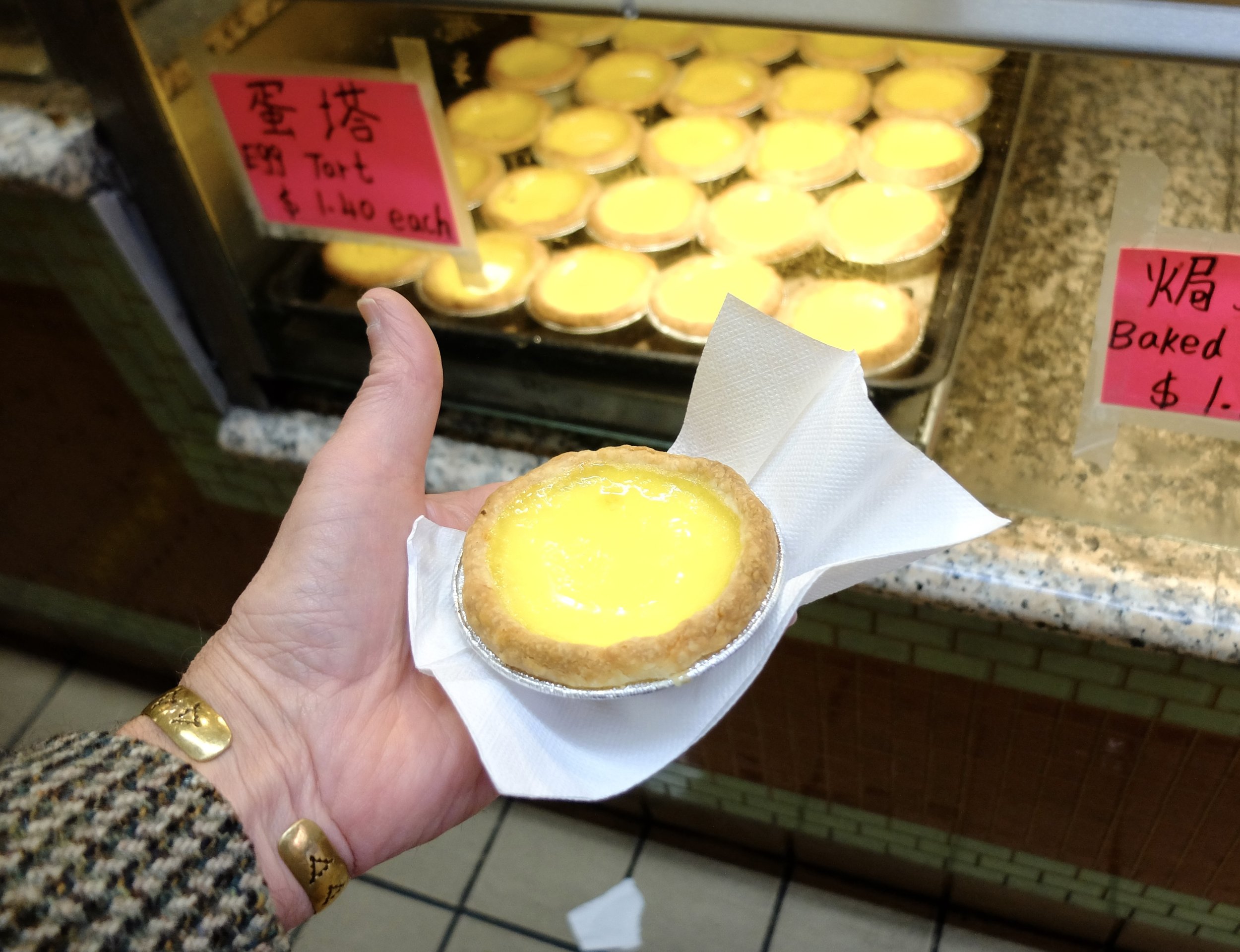 I walked out of an alley &amp; across the street was a small bakery.  I spied a tray filled with custard tarts still warm from the oven.  So very good.