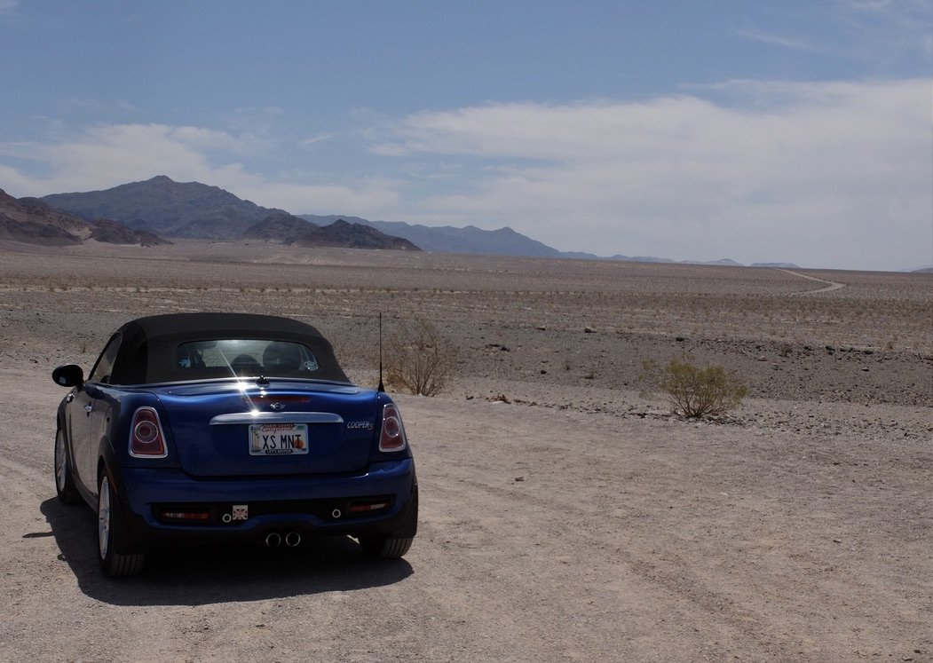  Death Valley - Badwater Road at Ashford Mill.  44 miles of flat desert driven with another 28 to Shoshone.  You can see the road curving in the distance.  Those are creosote plants.  They get more water by inhibiting the growth of nearby plants.   