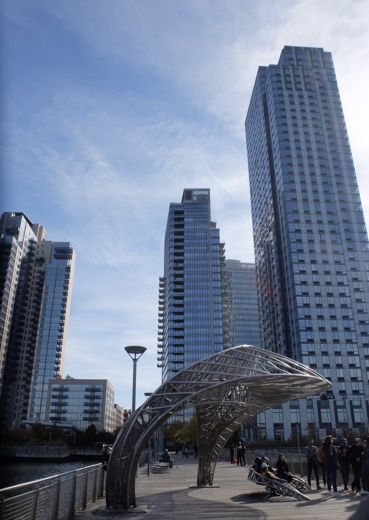   Mark Gibian's sculpture "Crescendo."  "The four-ton, crescent-shaped stainless steel sculpture was hoisted over the East River &amp; installed on the new 400-foot pier that's been constructed at Northside Piers. (May 2022)  The sculpture is functio