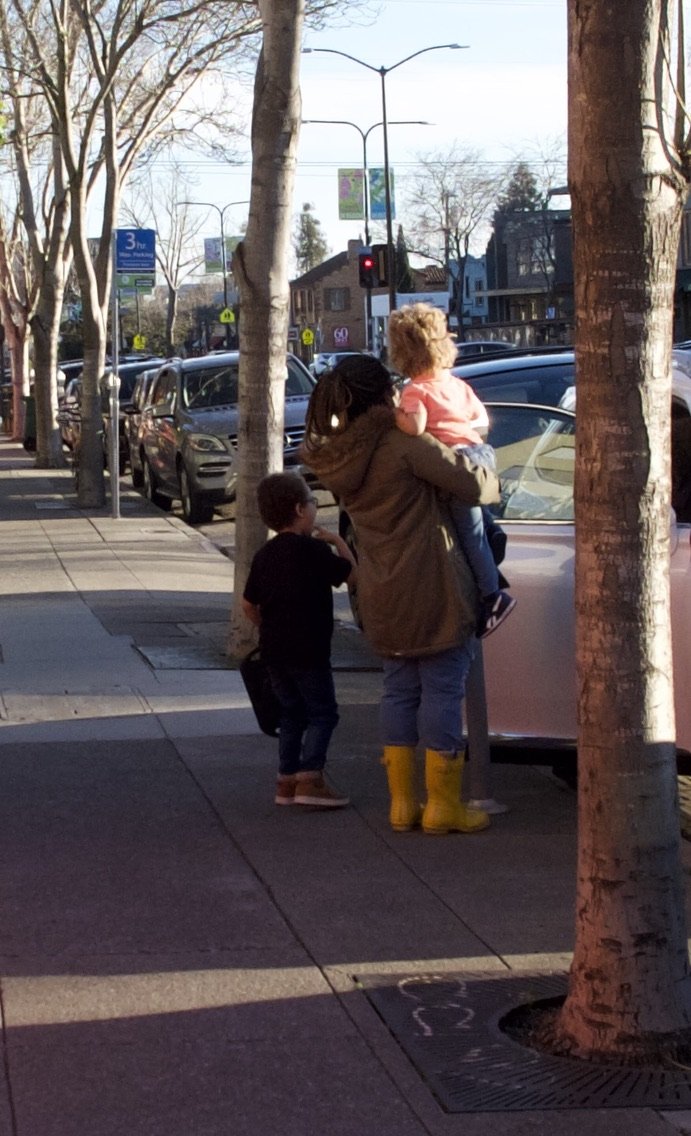  This cute family was having fun working the digital parking meter. 