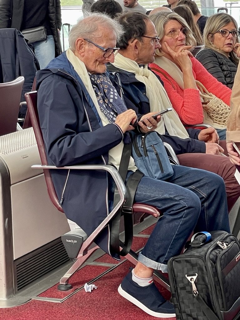  He was part of a church group on a mission led by a priest.   They were all wearing white scarves.  He must have left his teeth in his checked luggage.  Chas. de Gaulle airport. 