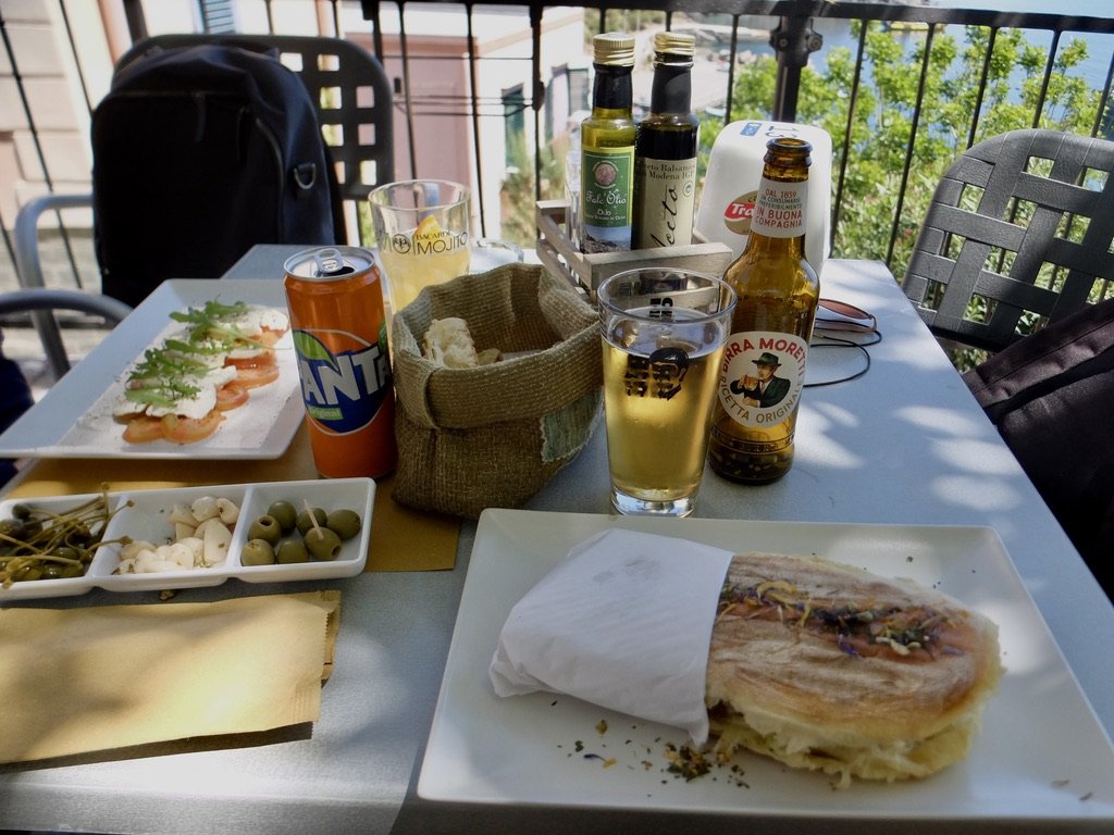  Then we found Carpe Diem overlooking the harbor.  The best appetizers ever; huge capers, delicious olives &amp; pickled garlic.  Then a caprese salad &amp; the best fish sandwich.  € 8.00:  “Mackerel in oil, charcoal-cooked oil, lettuce, liquid lemo