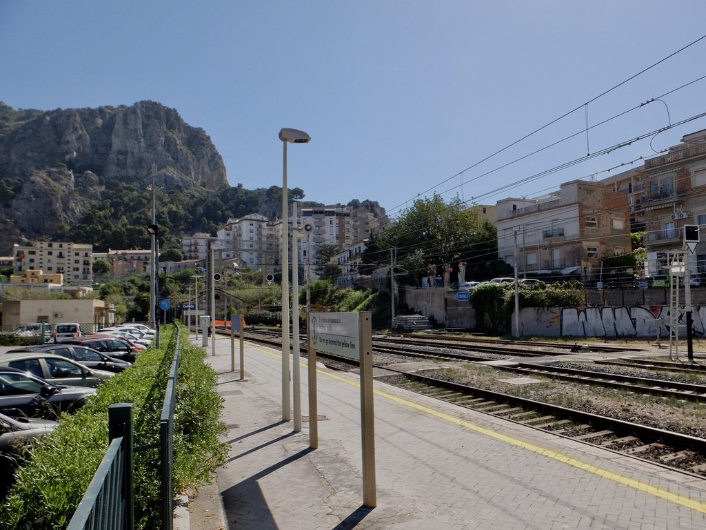  Cefalù railway station &amp; public parking.  Dominating the background is “ La Rocca , locally called  u castieddu  (the castle), is a fortified cliff 268 meters high overlooking the beautiful town of  Cefalù , rising on the Tyrrhenian coast, one o