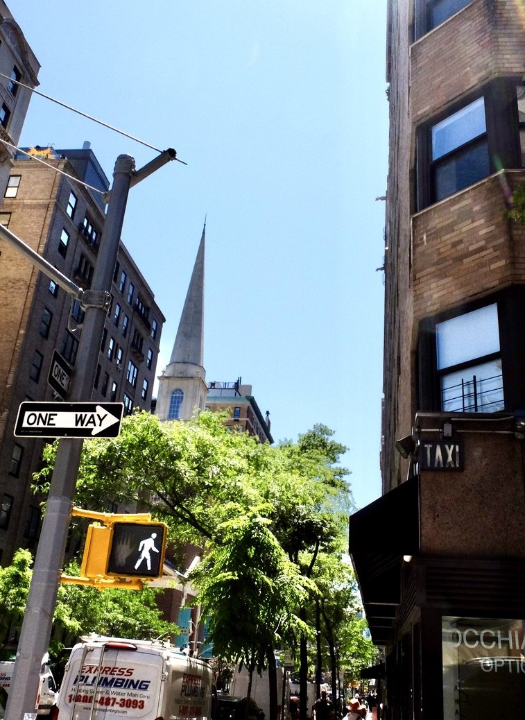  The  TAXI  sign above what was probably once the entrance to a hotel.   The spire is the Unitarian Church of All Souls; founded 1819. 