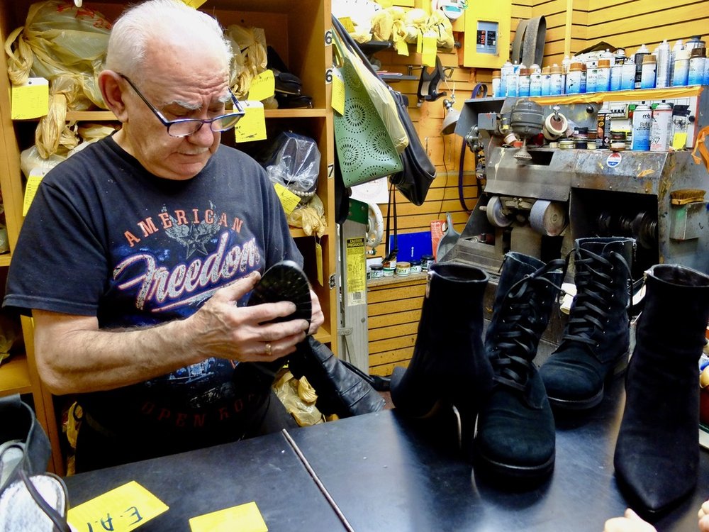  He glued Nomi's boot sole back in place.   These shoe repair shops are often squeezed between two buildings &amp; no more than two doors wide.  You’re seeing just about the entire width of the shop here. 