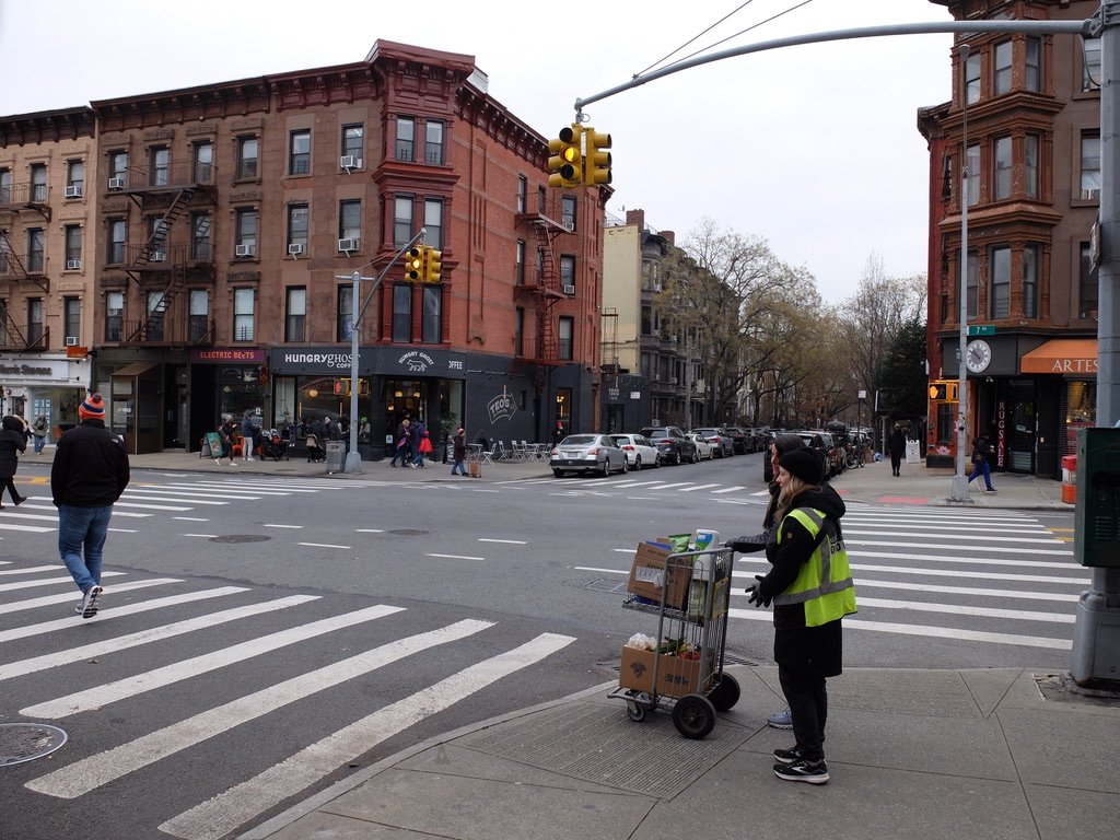  Park Slope Food Coop volunteer escorting a patron &amp; she'll return to the market with the cart. 