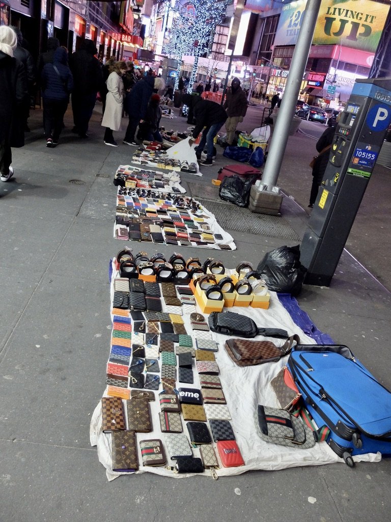 Unlicensed street vendors about to scoop up at a moment's notice as the police approach &amp; move on.  Times Sq.