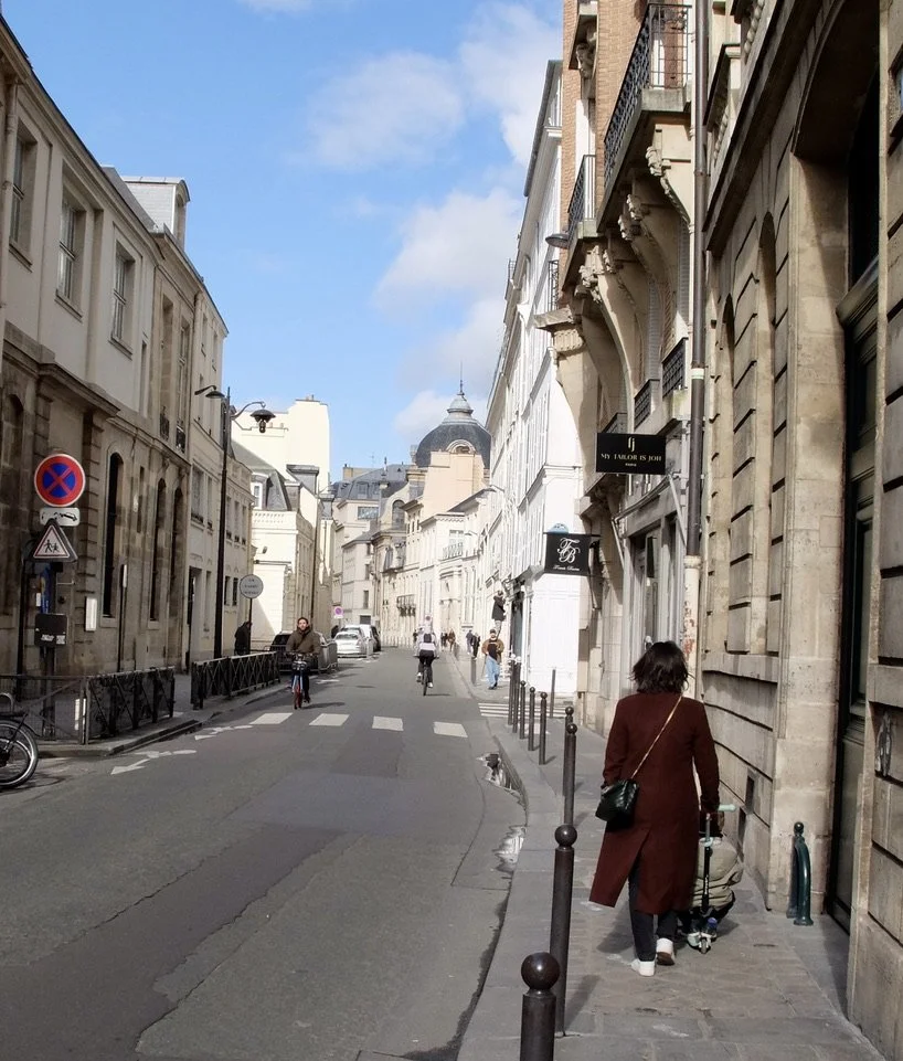 Pushing kid on sit down skateboard . These were all the rage here.- Rue de Grenelle