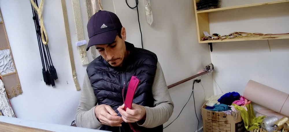  He was handcrafting custom belts for caftans.  We saw him twisting thread that he then used.  Meknes medina. 