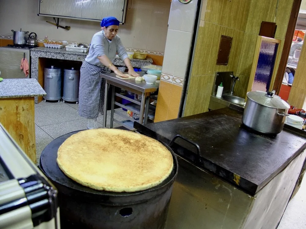  Restaurant Al A Khawayne, Ifrane.   A large wooden pallet was used to flip over the corn based bread.  That’s ever so delicious bean soup simmering in the pot. 