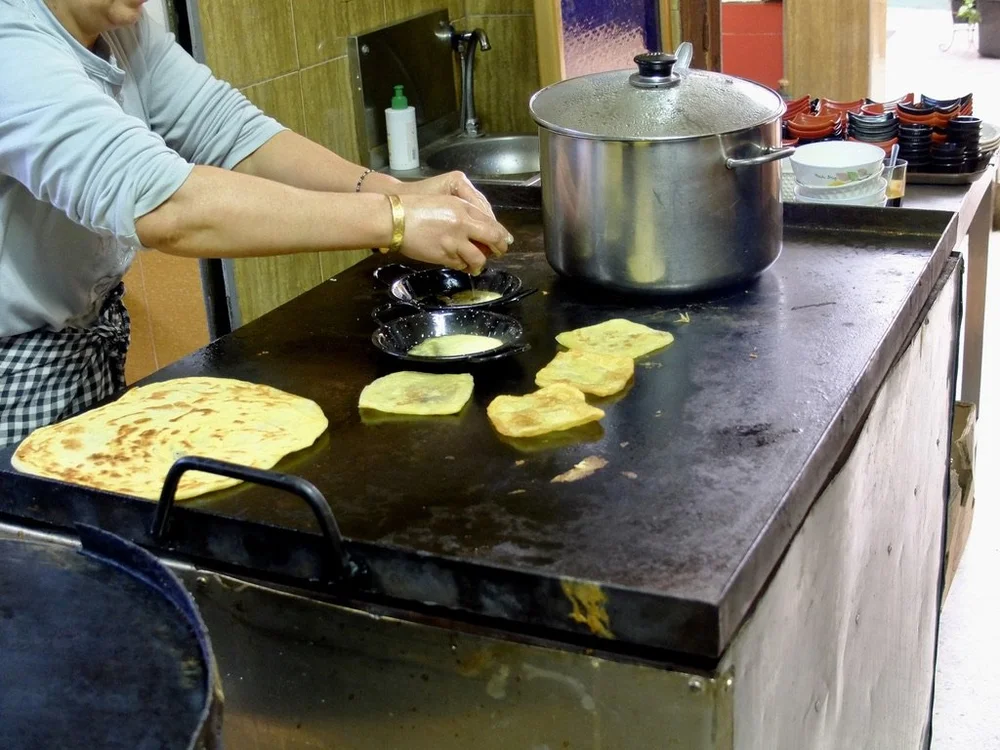  She warmed up the squares of bread that the staff from the Karawan Riad in Fes gave us with the take-away breakfast. Those are eggs cooking for us. 