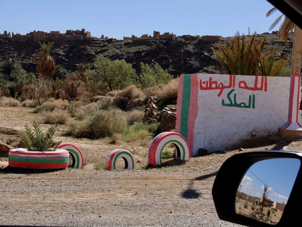  Near Alnif, an abandoned village above.  Below, the painted tires are warnings for drivers.  الله  Allah appears twice in that graffiti.  Most graffiti we saw had الله   