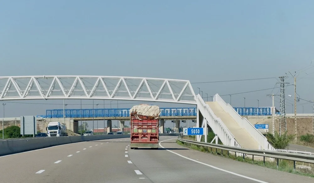  So many of the trucks seemed to be  overloaded &amp; top heavy.  As we approached Casablanca we went under multiple pedestrian bridges. 