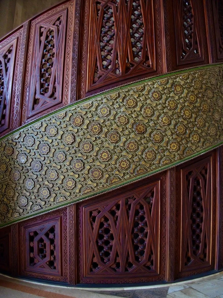  Carved wooden spiral staircase leading up to the women’s area. 