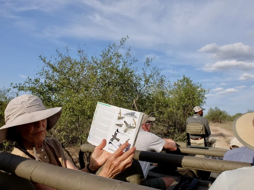  Lynn referring to our driver’s well-worn birding book.    Notten's Bush Camp, Sabi Sands Nature Preserve, South Africa. 