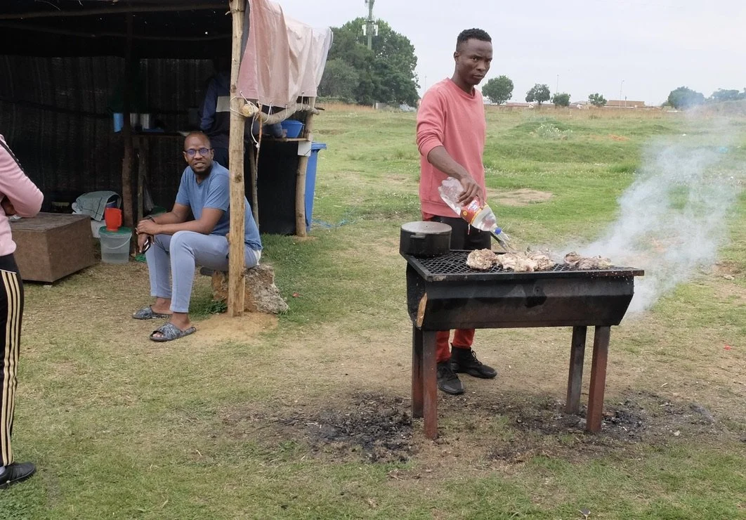  Our guide Jacob asked in Xhosa what he was barbecuing; cow intestines.  Soweto, Joburg, ZA. 